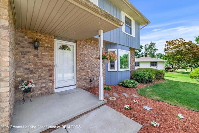 4629 Grandwoods Dr, Lansing, MI 48917 - property entrance with brick siding, a lawn, and board and batten siding