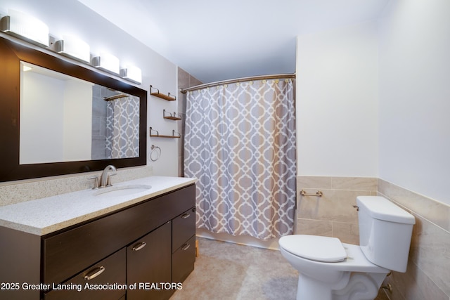 4629 Grandwoods Dr, Lansing, MI 48917 - bathroom with vanity, tile walls, a shower with shower curtain, and wainscoting