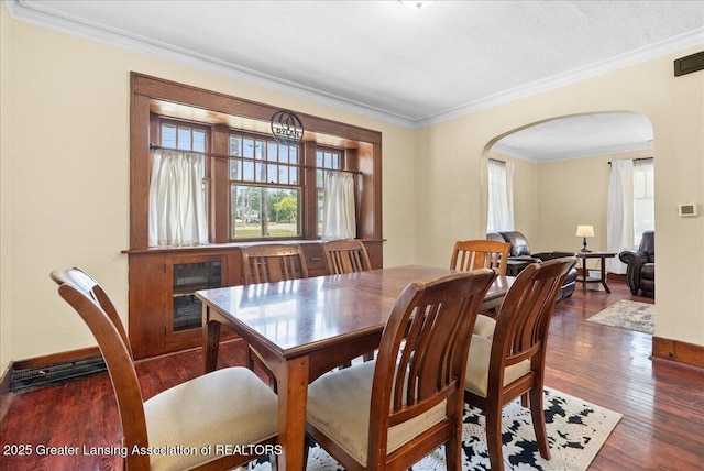 700 S Pennsylvania Ave, Lansing, MI 48912 - dining room with arched walkways, plenty of natural light, ornamental molding, and wood finished floors