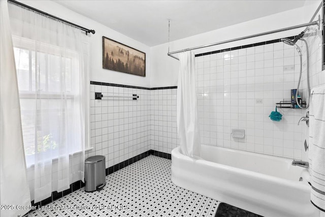 700 S Pennsylvania Ave, Lansing, MI 48912 - bathroom with tile walls, shower / bathtub combination with curtain, a wainscoted wall, and tile patterned flooring