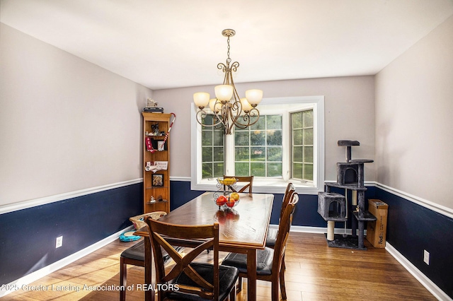 4326 Manitou Dr, Okemos, MI 48864 - dining area featuring a chandelier, a wood stove, and wood finished floors