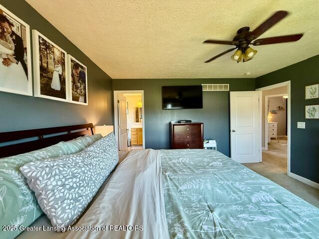 310 Brittany Ln, Mulliken, MI 48861 - bedroom featuring carpet flooring, a textured ceiling, and ensuite bathroom