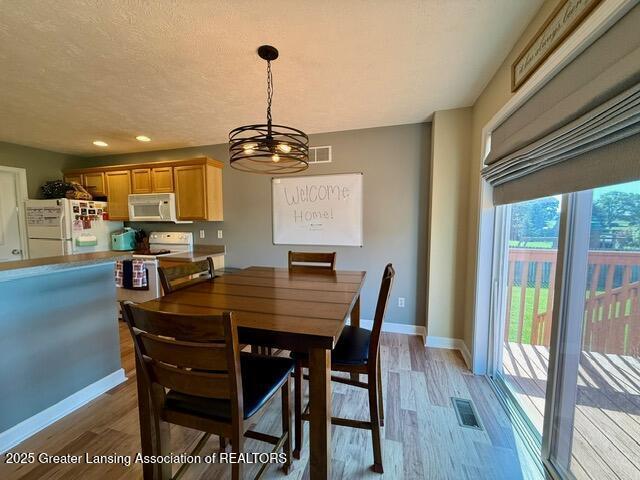 310 Brittany Ln, Mulliken, MI 48861 - dining area with light wood-type flooring, a chandelier, and recessed lighting