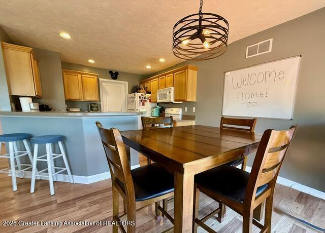 310 Brittany Ln, Mulliken, MI 48861 - dining room with light wood-style flooring, recessed lighting, and a chandelier