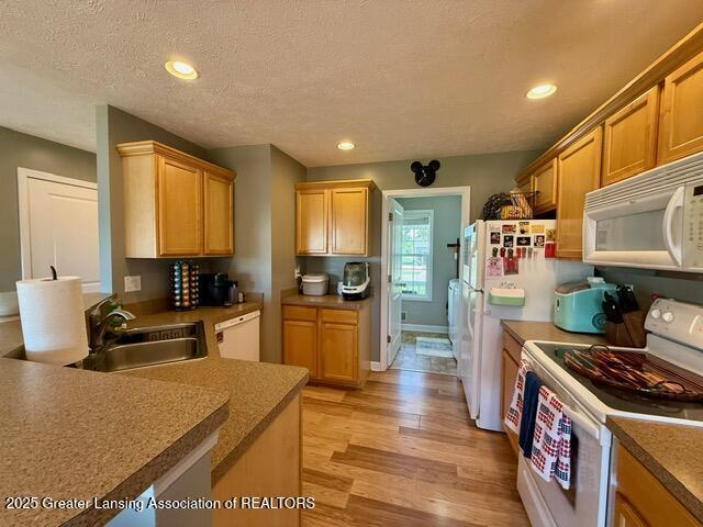 310 Brittany Ln, Mulliken, MI 48861 - kitchen featuring white appliances, light wood finished floors, recessed lighting, and a textured ceiling