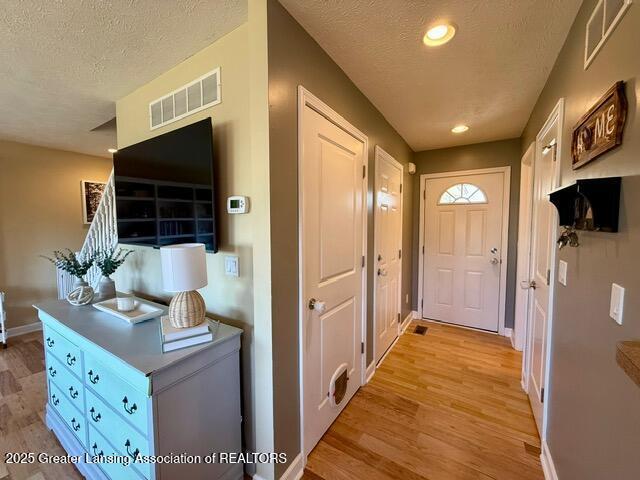 310 Brittany Ln, Mulliken, MI 48861 - doorway with light wood finished floors, a textured ceiling, and recessed lighting