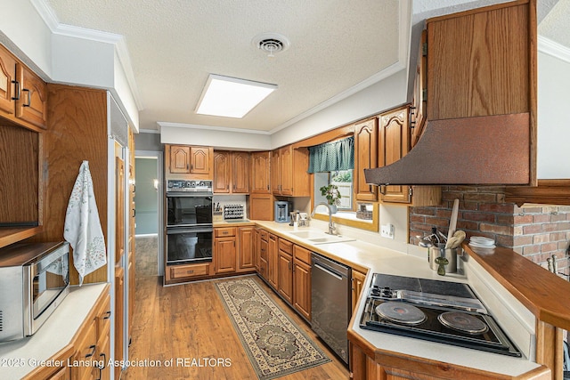 608 Belknap St, Grand Ledge, MI 48837 - kitchen featuring black appliances, ornamental molding, brown cabinets, light wood-type flooring, and a textured ceiling