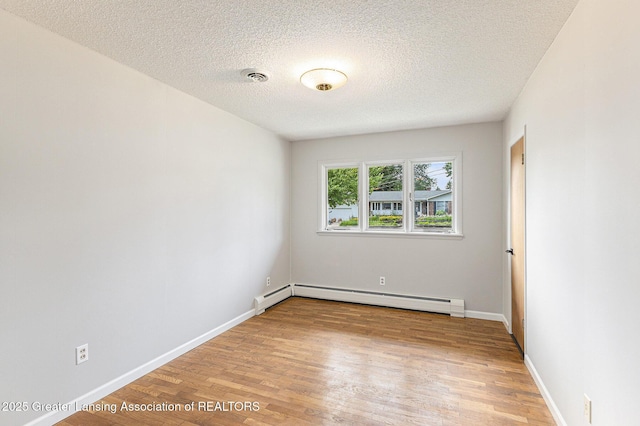 608 Belknap St, Grand Ledge, MI 48837 - empty room with a baseboard radiator, light wood finished floors, and a textured ceiling