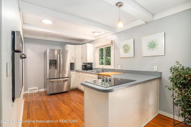 320 Mark St, Spring Lake, MI 49456 - kitchen with black appliances, a peninsula, beamed ceiling, light wood-style flooring, and hanging light fixtures