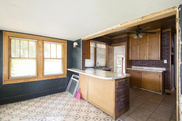 720 Kennedy St, Jackson, MI 49202 - kitchen with a peninsula, light countertops, ceiling fan, and brown cabinets