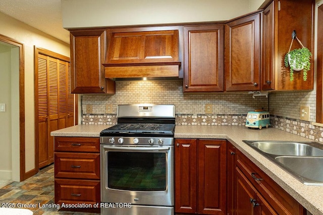 3536 Burkley Rd, Williamston, MI 48895 - kitchen featuring stainless steel gas range oven, decorative backsplash, light countertops, and custom exhaust hood