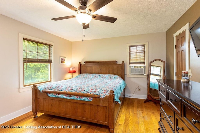 3536 Burkley Rd, Williamston, MI 48895 - bedroom featuring light wood finished floors, ceiling fan, a textured ceiling, and cooling unit