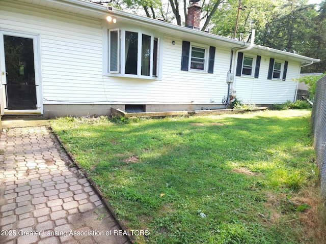 3612 Dell Rd, Holt, MI 48842 - view of home's exterior with a lawn and a chimney