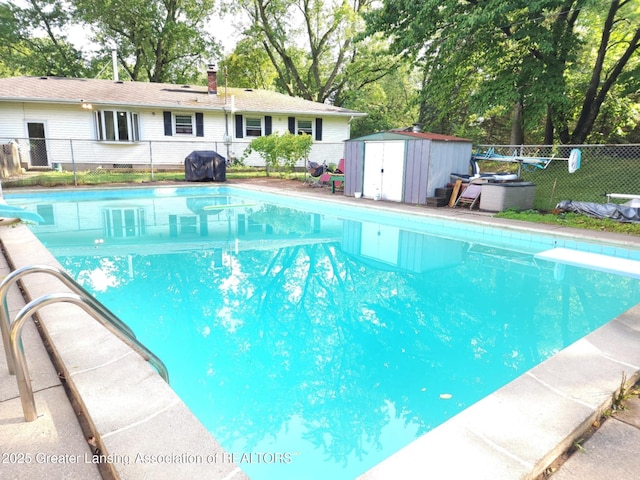 3612 Dell Rd, Holt, MI 48842 - view of pool featuring a storage unit, a diving board, area for grilling, and view of wooded area