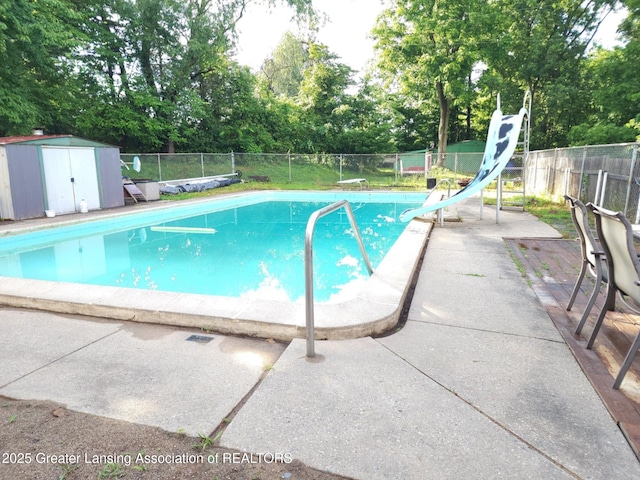 3612 Dell Rd, Holt, MI 48842 - view of swimming pool with a water slide, view of wooded area, and a fenced backyard