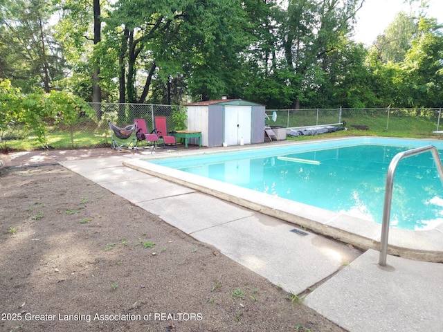 3612 Dell Rd, Holt, MI 48842 - view of swimming pool featuring a fenced backyard, view of wooded area, a storage unit, and a patio area