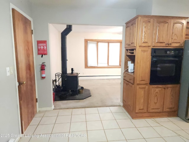 3612 Dell Rd, Holt, MI 48842 - kitchen featuring oven, light carpet, and a wood stove