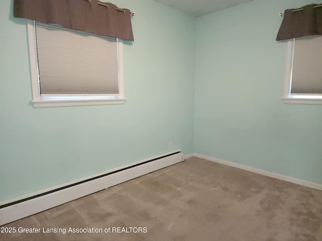 3612 Dell Rd, Holt, MI 48842 - spare room featuring a baseboard heating unit and carpet flooring