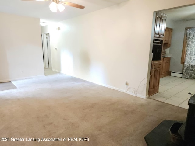 3612 Dell Rd, Holt, MI 48842 - unfurnished living room with a ceiling fan, light colored carpet, and a baseboard heating unit