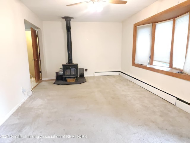 3612 Dell Rd, Holt, MI 48842 - unfurnished living room with a wood stove, ceiling fan, healthy amount of natural light, and carpet flooring