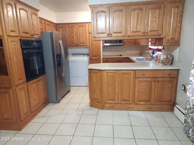 3612 Dell Rd, Holt, MI 48842 - kitchen with black appliances, a peninsula, light countertops, a baseboard radiator, and light tile patterned floors