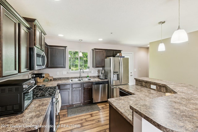 4930 N Campers Trl, Perrinton, MI 48871 - kitchen with stainless steel appliances, light wood-style floors, dark countertops, decorative light fixtures, and recessed lighting