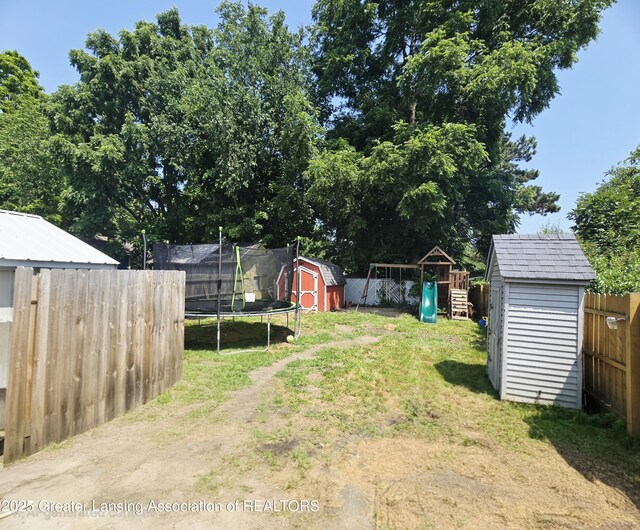 412 N Hickory St, Owosso, MI 48867 - fenced backyard with a shed, a trampoline, and a playground