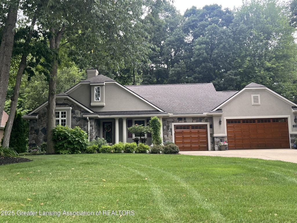 15316 Club Course Dr, Bath, MI 48808 - view of front of property with stone siding, stucco siding, and a garage