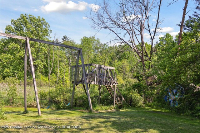 7050 E Eaton Hwy, Sunfield, MI 48890 - view of playground with stairs, a deck, and a forest view