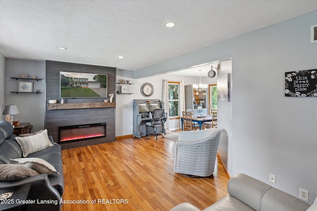 129 Elizabeth Way, Potterville, MI 48876 - living area with wood finished floors, a large fireplace, a chandelier, and recessed lighting