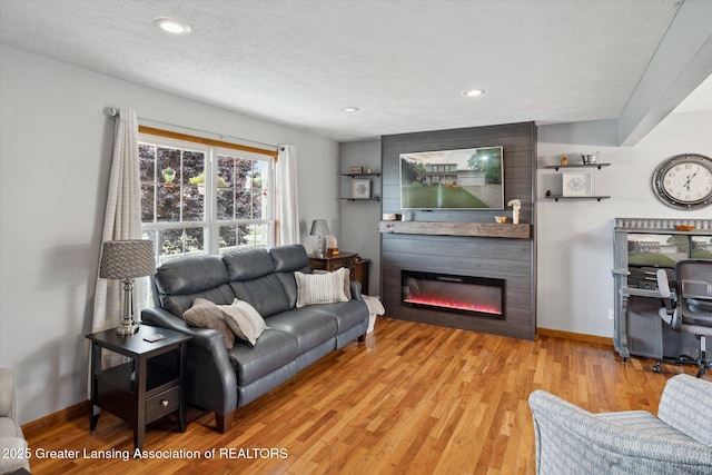 129 Elizabeth Way, Potterville, MI 48876 - living area with wood finished floors, a large fireplace, recessed lighting, and a textured ceiling