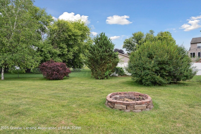 129 Elizabeth Way, Potterville, MI 48876 - fenced backyard featuring an outdoor fire pit