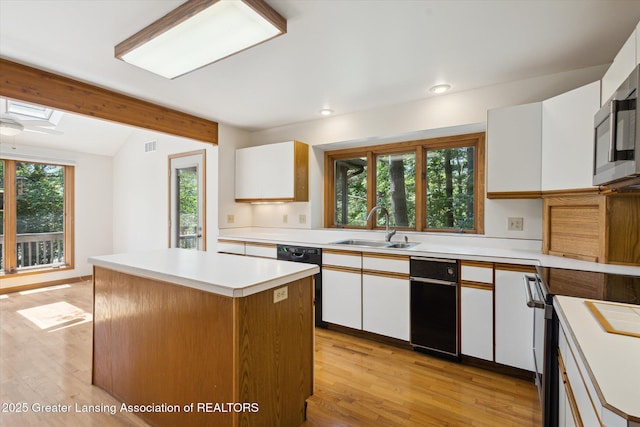 2575 Capeside Dr, Okemos, MI 48864 - kitchen with stainless steel appliances, white cabinets, a kitchen island, light countertops, and light wood finished floors