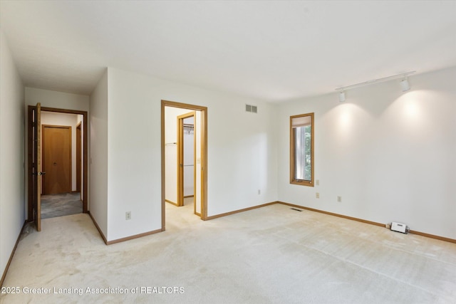 2575 Capeside Dr, Okemos, MI 48864 - spare room with rail lighting and light colored carpet