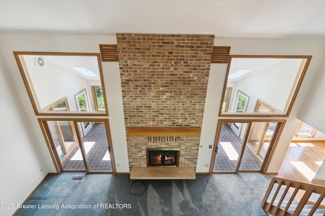 2575 Capeside Dr, Okemos, MI 48864 - unfurnished living room with a skylight, a high ceiling, carpet, and a fireplace