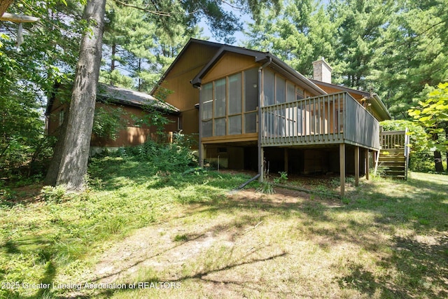 2575 Capeside Dr, Okemos, MI 48864 - rear view of property featuring a sunroom, stairs, a wooden deck, a chimney, and a yard