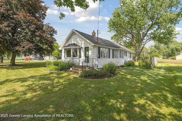 873 Union Ave, Owosso, MI 48867 - view of front facade featuring a chimney, a front lawn, and a shingled roof