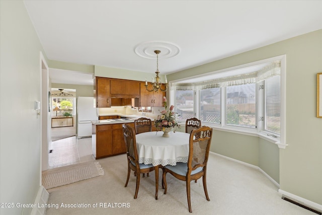 873 Union Ave, Owosso, MI 48867 - dining room featuring a chandelier and light colored carpet