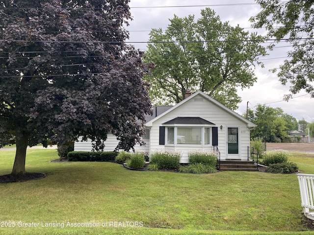 873 Union Ave, Owosso, MI 48867 - view of front facade featuring a front yard, a chimney, and roof with shingles