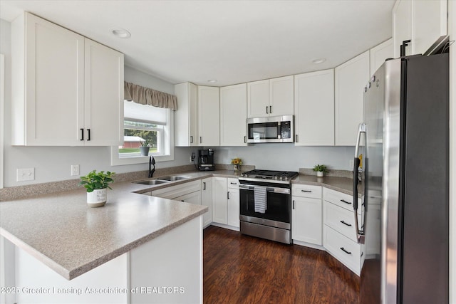 112 E Barber St, Ithaca, MI 48847 - kitchen featuring appliances with stainless steel finishes, a peninsula, dark wood-style flooring, white cabinets, and recessed lighting