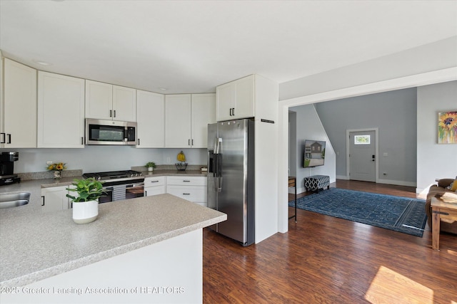 112 E Barber St, Ithaca, MI 48847 - kitchen with stainless steel appliances, white cabinets, and dark wood finished floors