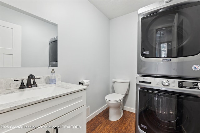 112 E Barber St, Ithaca, MI 48847 - bathroom featuring stacked washer / dryer, vanity, and wood finished floors