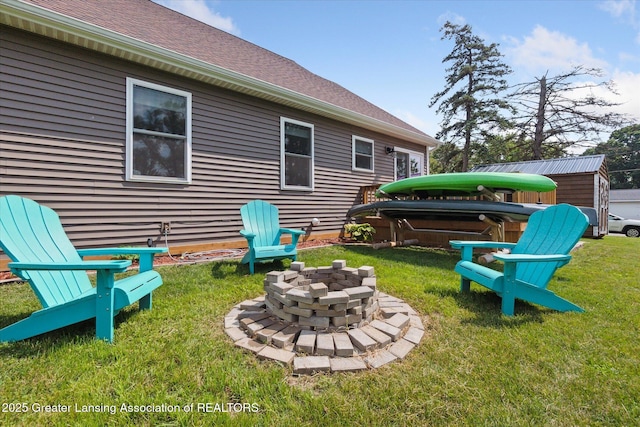 112 E Barber St, Ithaca, MI 48847 - view of grassy yard featuring a hot tub, a fire pit, and a storage shed