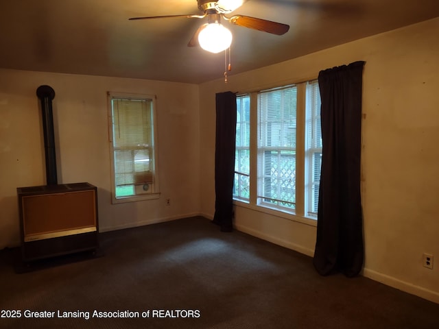 518 Clark St, Eaton Rapids, MI 48827 - unfurnished living room featuring a wood stove, ceiling fan, and carpet floors
