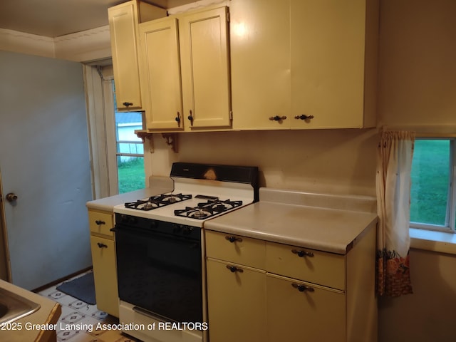 518 Clark St, Eaton Rapids, MI 48827 - kitchen featuring gas range oven, light countertops, and white cabinets