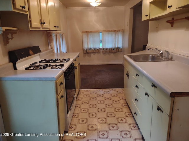 518 Clark St, Eaton Rapids, MI 48827 - kitchen featuring gas range gas stove, light countertops, light carpet, light flooring, and white cabinetry