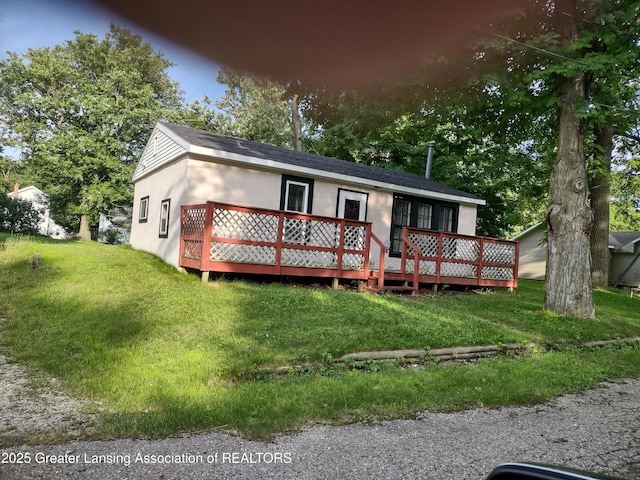 518 Clark St, Eaton Rapids, MI 48827 - view of front facade featuring a wooden deck, a front lawn, and stucco siding