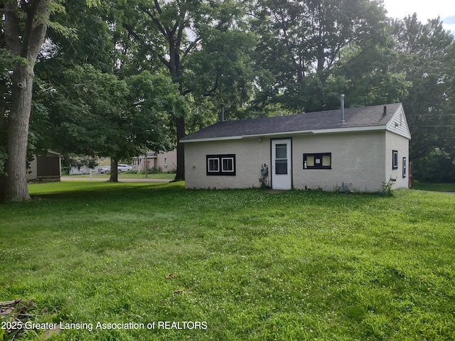 518 Clark St, Eaton Rapids, MI 48827 - rear view of property with a lawn and stucco siding