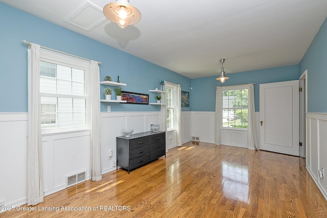 720 Linden St, East Lansing, MI 48823 - dining space featuring wainscoting, light wood-style floors, and a decorative wall