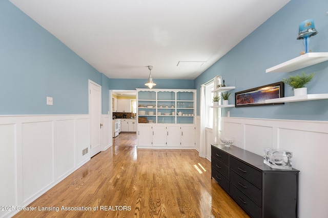 720 Linden St, East Lansing, MI 48823 - dining area with wainscoting, light wood finished floors, and a decorative wall